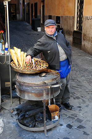 Street vender selling roasted chestnuts in Rome near the Trevi fountain.